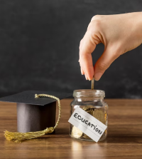 Hand dropping a coin into a jar labeled "Education" with a graduation cap nearby.